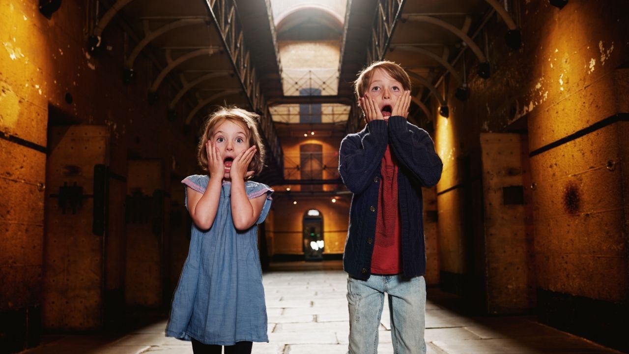 Two children with surprised faces inside Old Melbourne Gaol